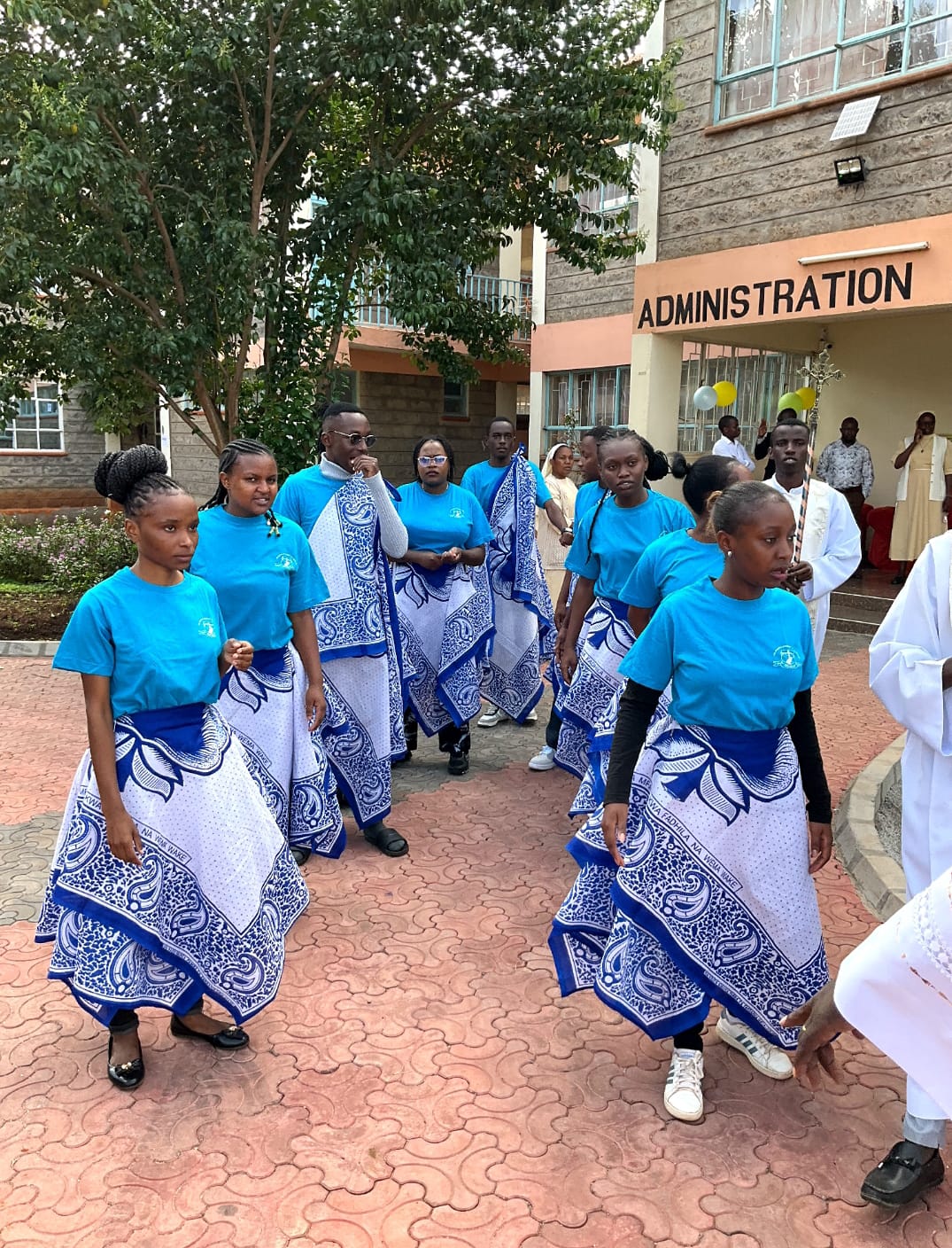 Students in traditional dance attire outside the administration block