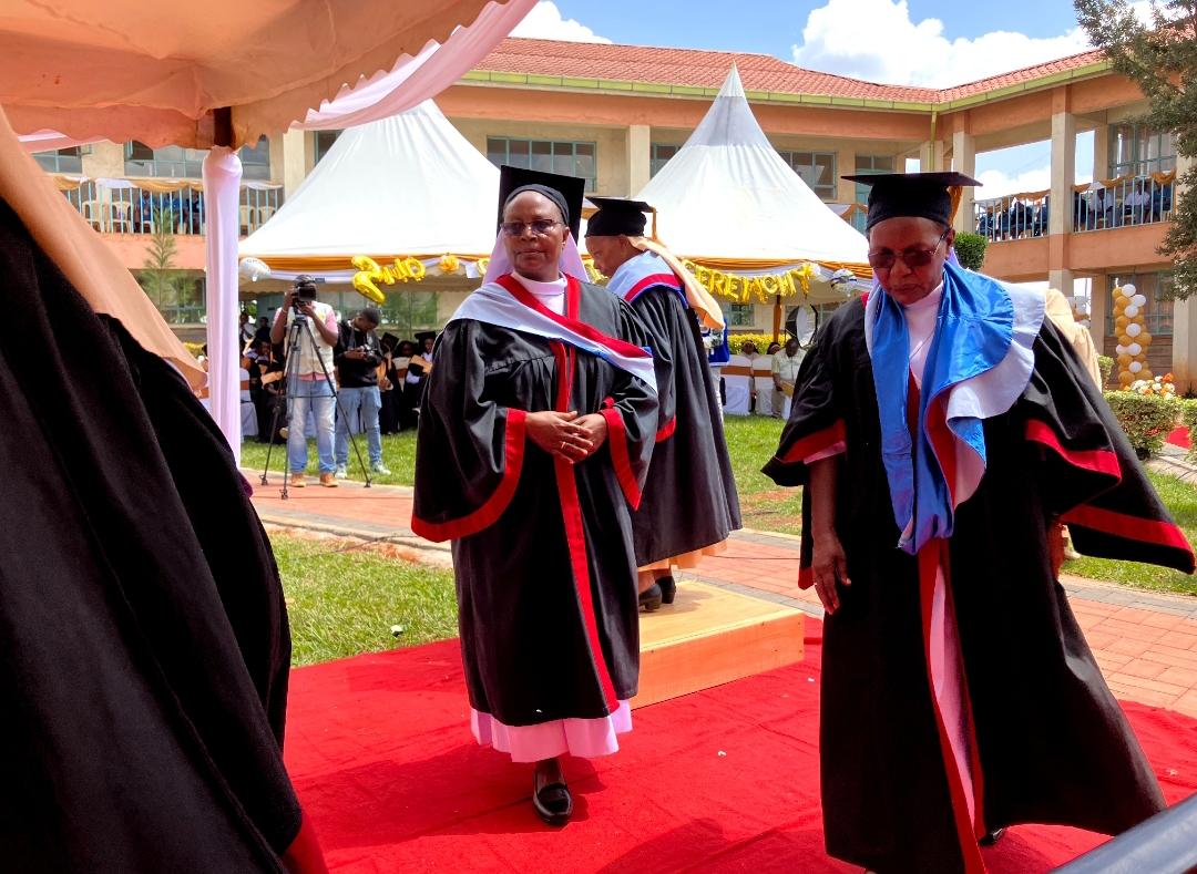 Sisters in academic regalia during the graduation procession
