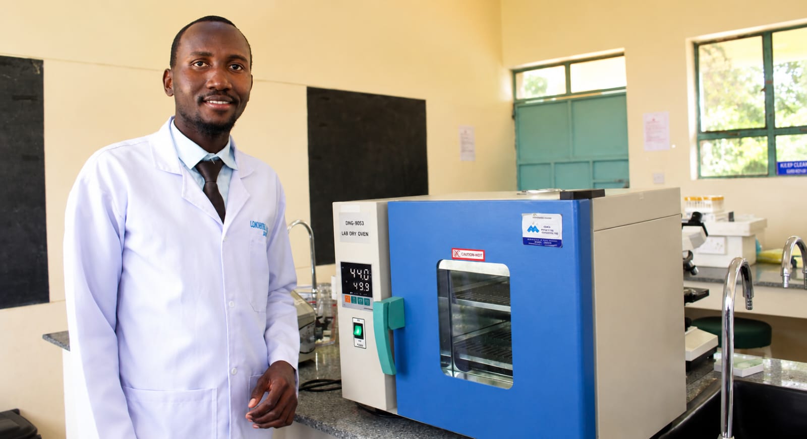 A laboratory tutor next to the lab dry oven in the science laboratory